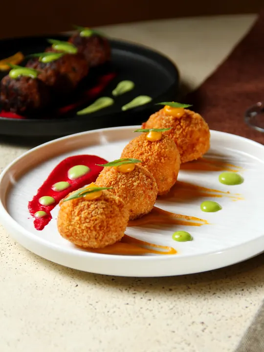 Golden fried bites plated with bright sauces